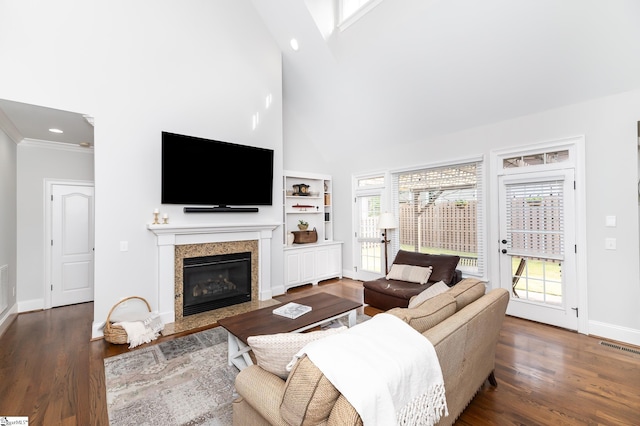 living room featuring a towering ceiling, dark hardwood / wood-style floors, and a wealth of natural light