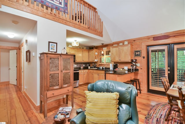 kitchen with decorative backsplash, light hardwood / wood-style flooring, light brown cabinets, and stainless steel stove