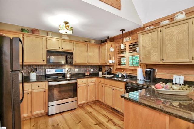 kitchen featuring black appliances, light brown cabinetry, light hardwood / wood-style floors, decorative light fixtures, and dark stone countertops