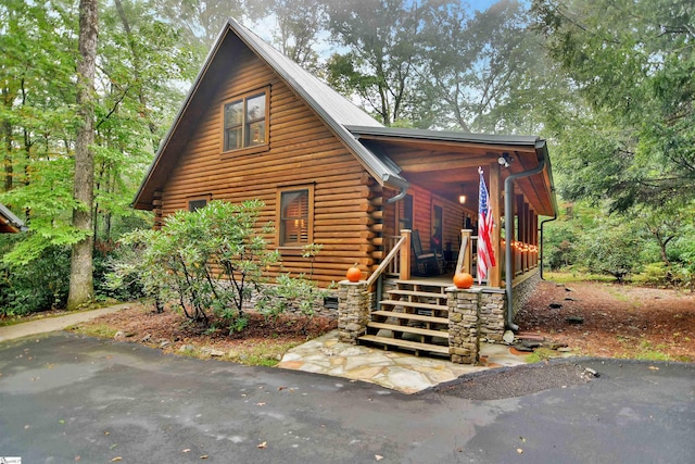 log cabin featuring covered porch