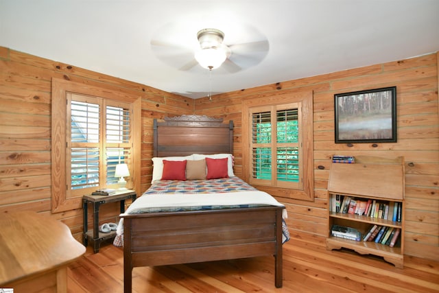 bedroom with wood walls, wood-type flooring, and ceiling fan