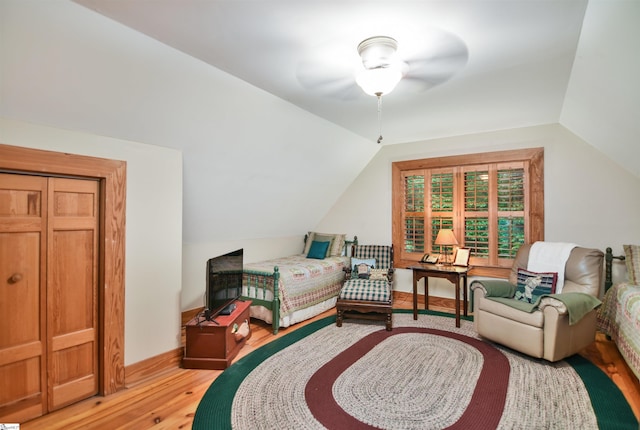 bedroom with a closet, vaulted ceiling, light wood-type flooring, and ceiling fan