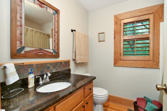 bathroom with vanity, toilet, tasteful backsplash, and hardwood / wood-style floors