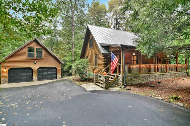 view of side of home with a porch, an outdoor structure, and a garage