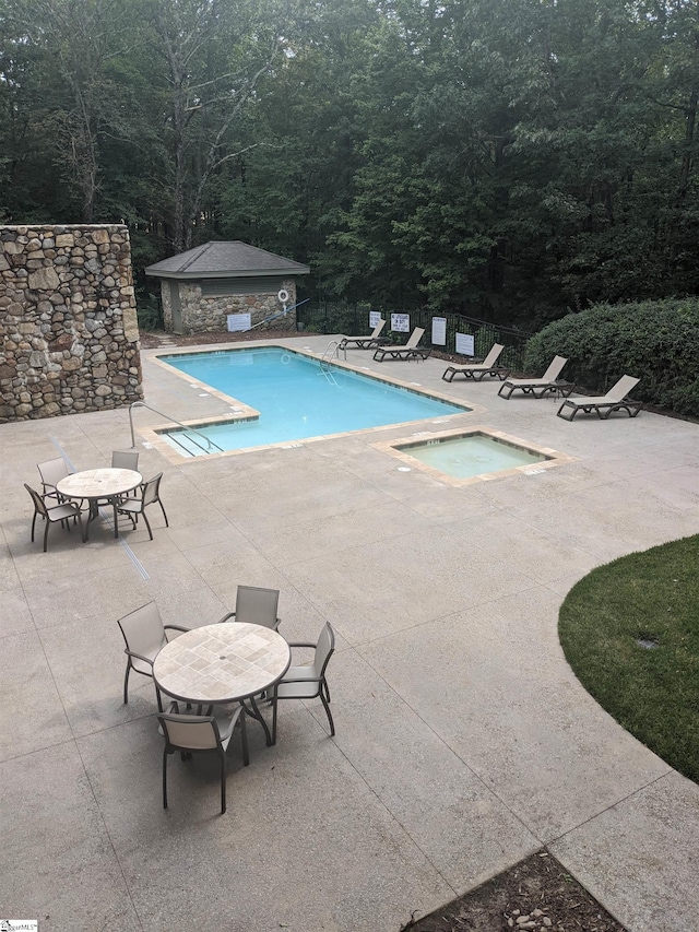 view of pool with a hot tub and a patio area