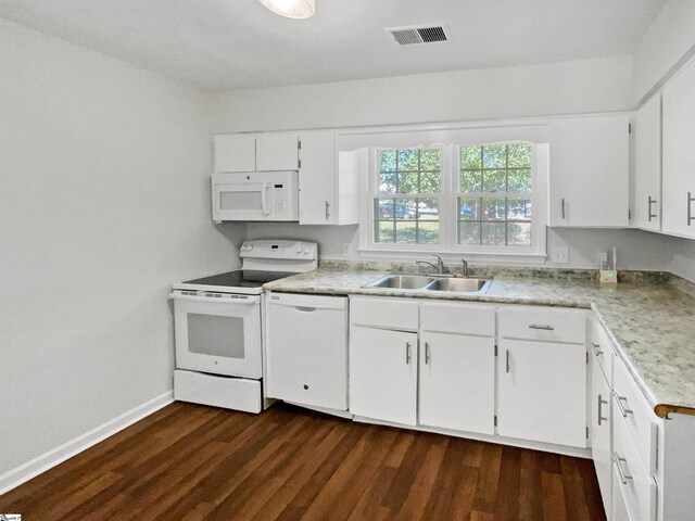 kitchen with visible vents, white appliances, light countertops, a sink, and dark wood finished floors