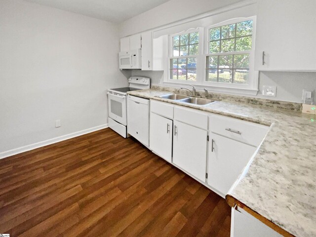 kitchen with dark wood-type flooring, a sink, white cabinetry, and white appliances