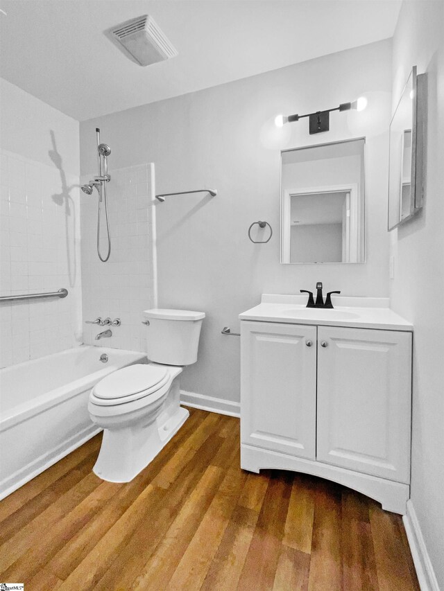 full bath with visible vents, wood finished floors, vanity, toilet, and shower / bathtub combination