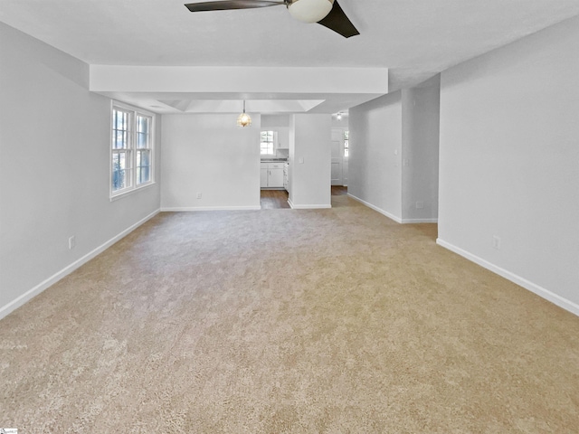 unfurnished living room featuring ceiling fan and light colored carpet