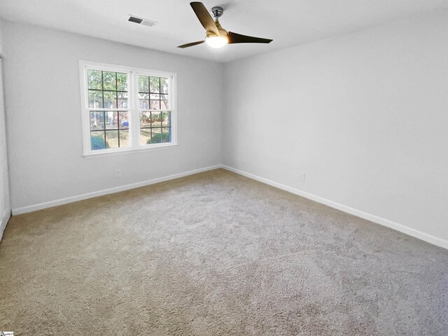 carpeted empty room featuring visible vents, baseboards, and ceiling fan