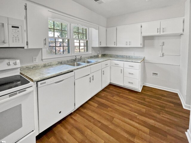 kitchen with a sink, light countertops, white cabinets, dark wood-style floors, and white appliances