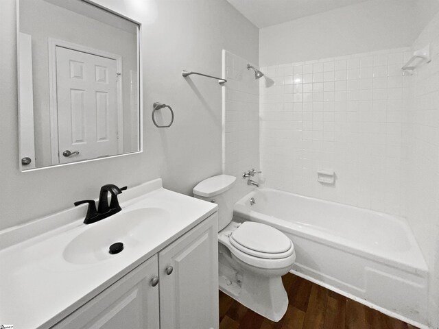 bathroom featuring vanity, shower / bathing tub combination, wood finished floors, and toilet