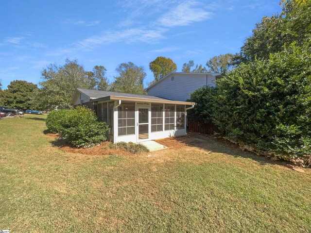 view of side of property featuring a yard and a sunroom