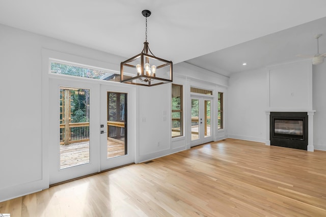 interior space featuring french doors, wood-type flooring, and an inviting chandelier