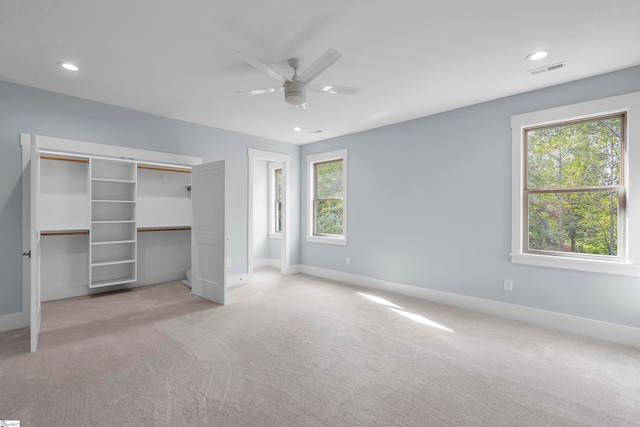 unfurnished bedroom with a closet, ceiling fan, and light colored carpet