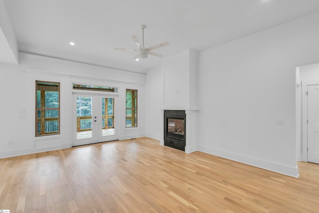 unfurnished living room with french doors, light hardwood / wood-style flooring, and ceiling fan