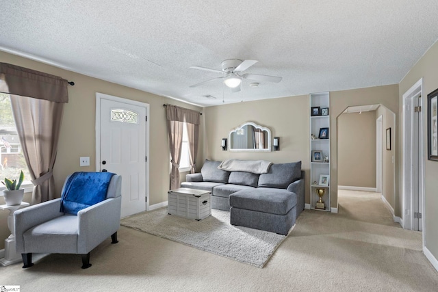 carpeted living room with ceiling fan and a textured ceiling