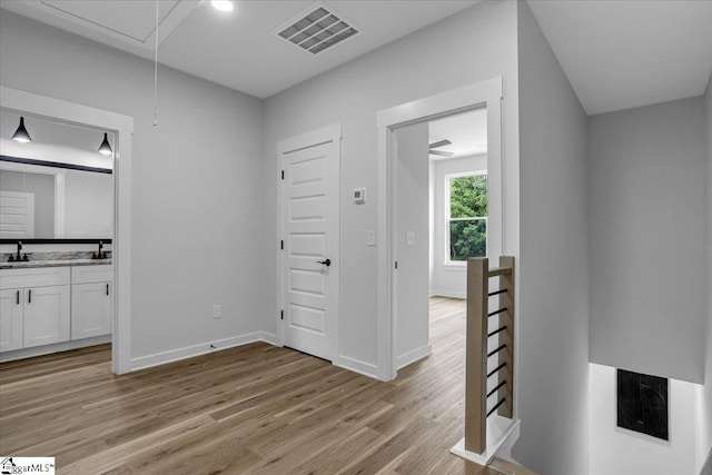 hall with sink and light wood-type flooring