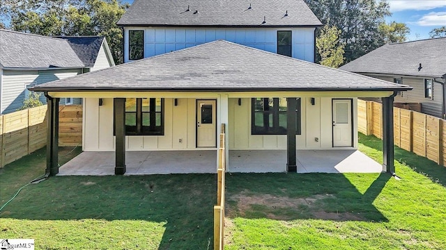 back of property with a patio area and a lawn