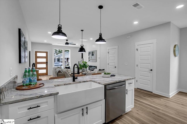 kitchen featuring hanging light fixtures, stainless steel dishwasher, white cabinetry, light hardwood / wood-style floors, and ceiling fan