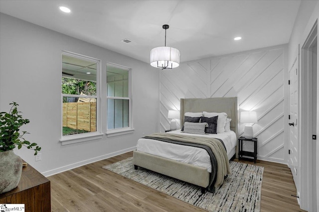 bedroom featuring a notable chandelier and hardwood / wood-style flooring