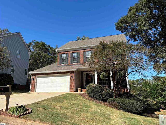 view of front of property with a garage, driveway, brick siding, and a front lawn