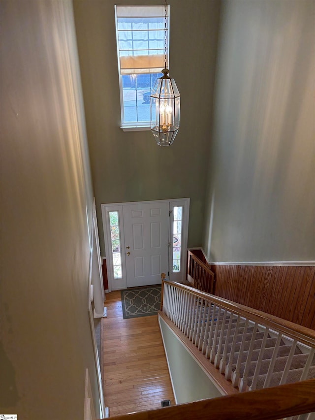 foyer with a high ceiling, wood-type flooring, and a chandelier