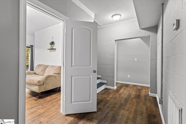 corridor with a textured ceiling and dark hardwood / wood-style floors