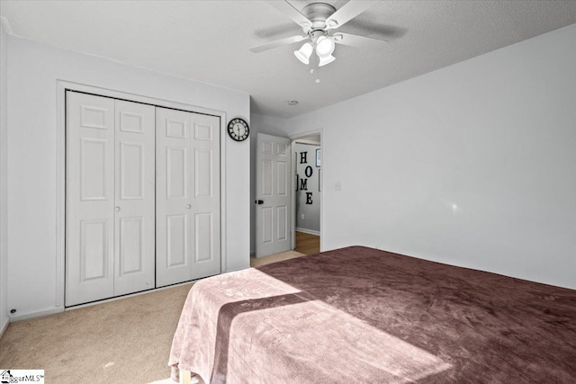 carpeted bedroom featuring a textured ceiling, a closet, and ceiling fan