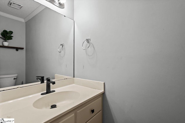 bathroom with vanity, toilet, crown molding, and a textured ceiling