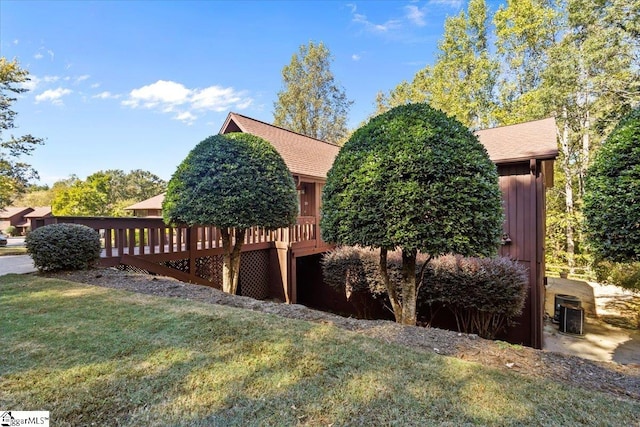 view of side of home with a yard and a deck