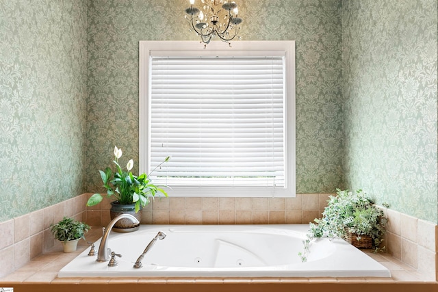 bathroom featuring a tub to relax in and an inviting chandelier