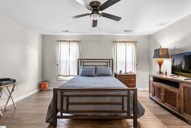 bedroom featuring multiple windows, hardwood / wood-style flooring, and ceiling fan