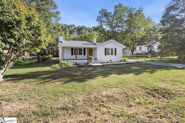 single story home featuring a front yard, covered porch, and solar panels