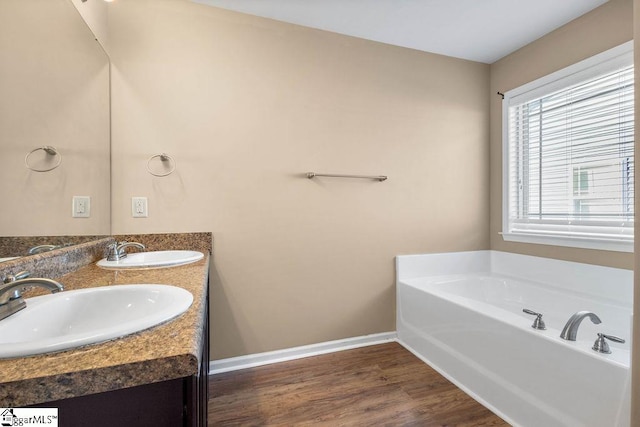 bathroom with a bathtub, hardwood / wood-style flooring, and vanity