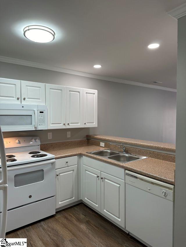 kitchen featuring white appliances, ornamental molding, dark hardwood / wood-style flooring, and white cabinets