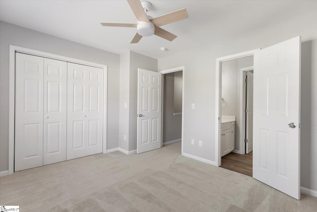 unfurnished bedroom featuring connected bathroom, light carpet, a closet, and ceiling fan