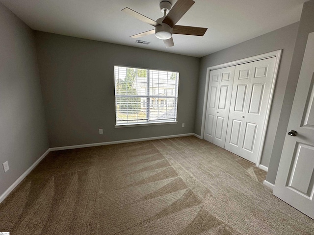 unfurnished bedroom with light colored carpet, a closet, and ceiling fan