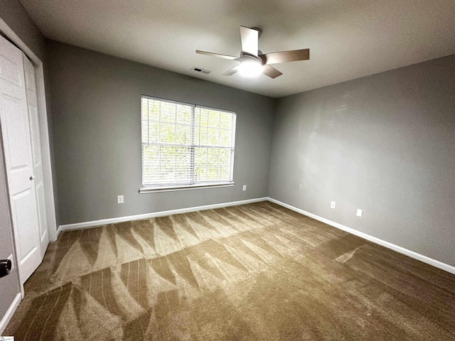 carpeted empty room featuring ceiling fan