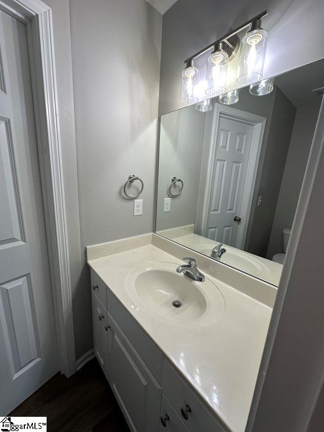 bathroom with vanity, hardwood / wood-style floors, and toilet