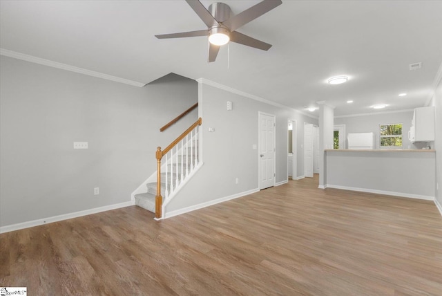 unfurnished living room with ornate columns, ornamental molding, light wood-type flooring, and ceiling fan