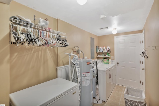 laundry area with light tile patterned floors, electric water heater, and washer and clothes dryer