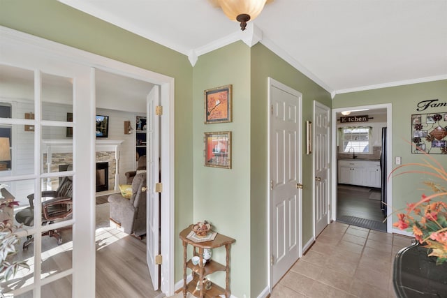 hallway with ornamental molding and light hardwood / wood-style flooring