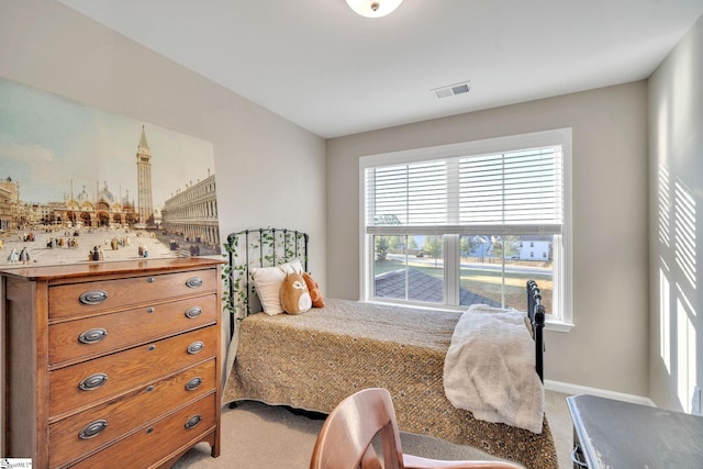 bedroom with multiple windows and light colored carpet