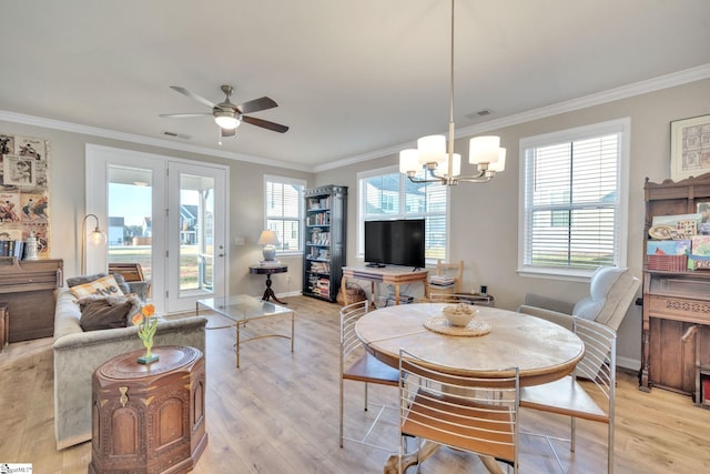 living room featuring a wealth of natural light, crown molding, light hardwood / wood-style flooring, and ceiling fan with notable chandelier