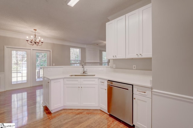 kitchen with kitchen peninsula, dishwasher, white cabinets, and sink