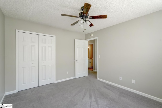 unfurnished bedroom featuring a closet, ceiling fan, light carpet, and a textured ceiling