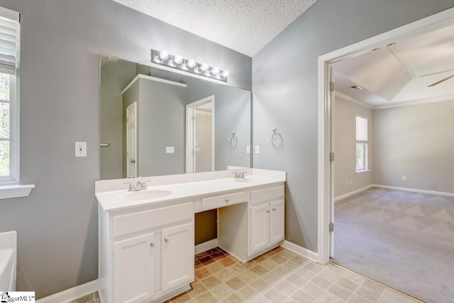 bathroom featuring vanity, a textured ceiling, ceiling fan, and a wealth of natural light