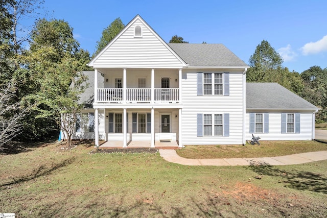 view of front of property with a balcony and a front lawn