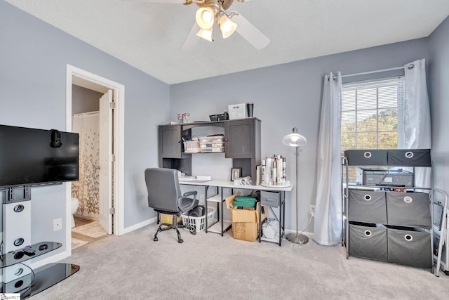 carpeted office featuring a textured ceiling and ceiling fan